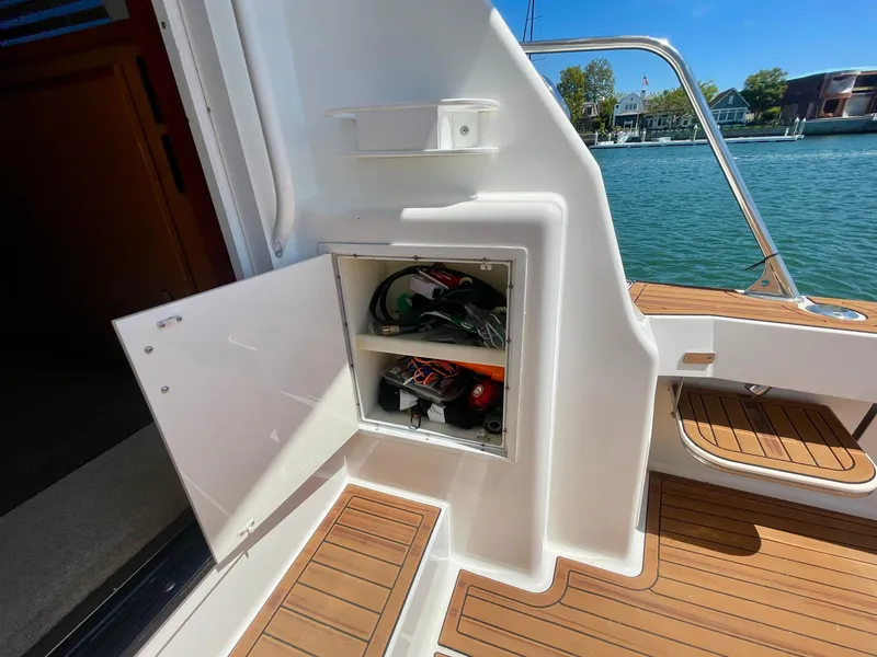 Slide: The Image of Open storage compartment on 1998 Viking 50 Convertible boat, docked by the water. - 26