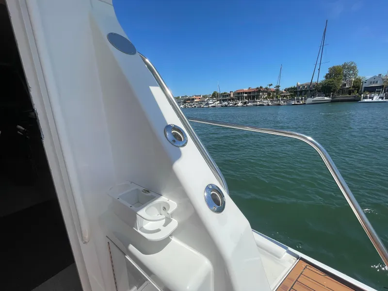 Slide: The Image of 1998 Viking 50 Convertible yacht with marina view, featuring sleek design and stainless steel railings. - 27