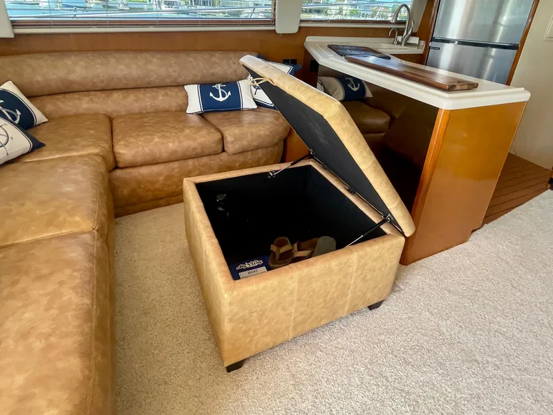 Slide: The Image of Luxurious interior of 1998 Viking 50 Convertible yacht with leather seating and storage ottoman. - 29