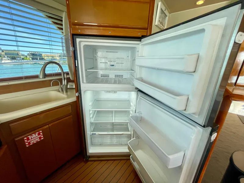 Slide: The Image of Open refrigerator in 1998 Viking 50 Convertible yacht kitchen, with wooden cabinetry and window view. - 36