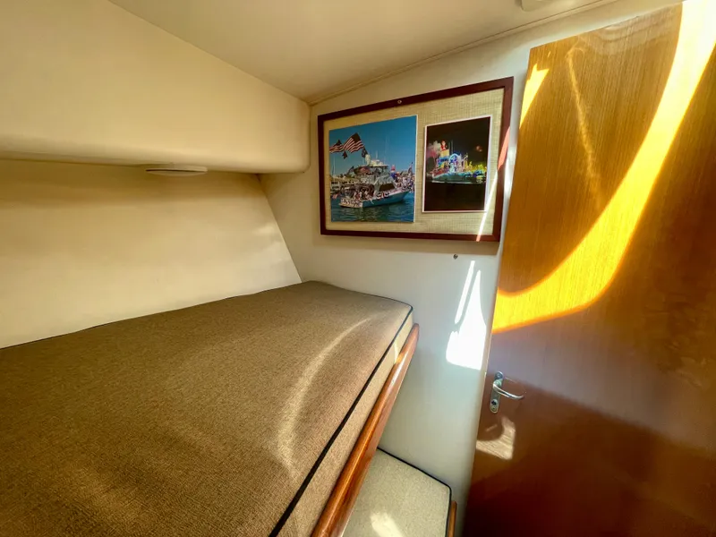Slide: The Image of Cozy cabin interior of 1998 Viking 50 Convertible yacht with framed nautical photos. - 44