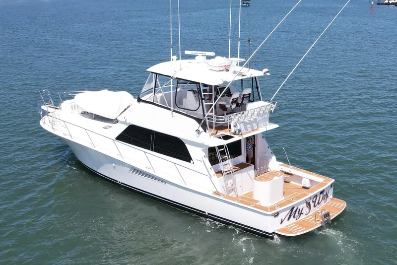 Slide: The Image of 1998 Viking 50 Convertible yacht cruising on open water, showcasing sleek design and spacious deck. - 5