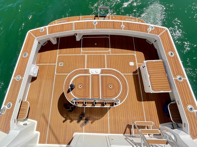 Slide: The Image of 1998 Viking 50 Convertible yacht deck with teak flooring and fishing rod holders. - 8