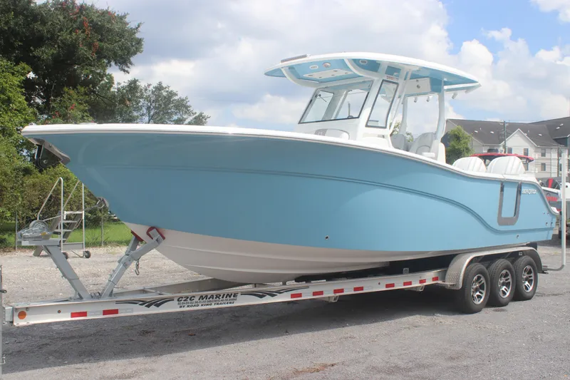 Slide: The Image of 2026 Sea Fox 288 Commander boat on trailer, light blue hull, parked outdoors. - 2