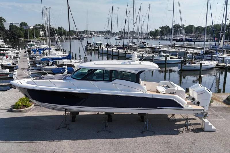 Slide: The Image of 2026 Tiara Yachts 43 LE docked at a marina with sailboats in the background. - 0