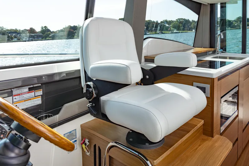 Slide: The Image of Captain's chair in 2025 Tiara Yachts 43 LE, overlooking serene waters. - 24
