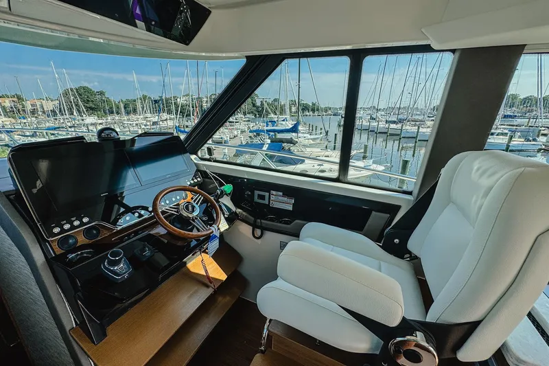 Slide: The Image of Interior of 2026 Tiara Yachts 43 LE, featuring helm and marina view. - 5