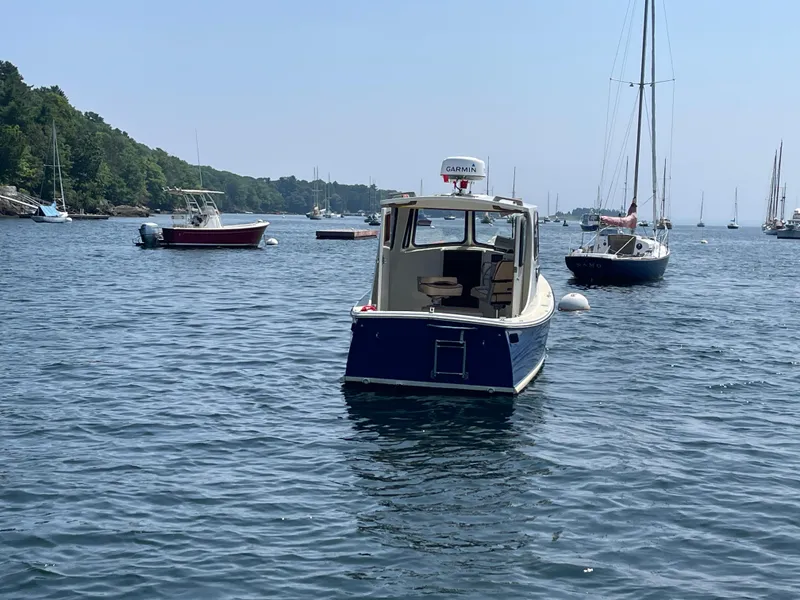 Slide: The Image of 2005 Atlas Boat Works Pompano 21 on calm water, surrounded by sailboats. - 10
