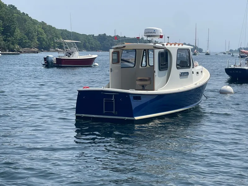 Slide: The Image of 2005 Atlas Boat Works Pompano 21 on calm water, surrounded by other boats. - 11