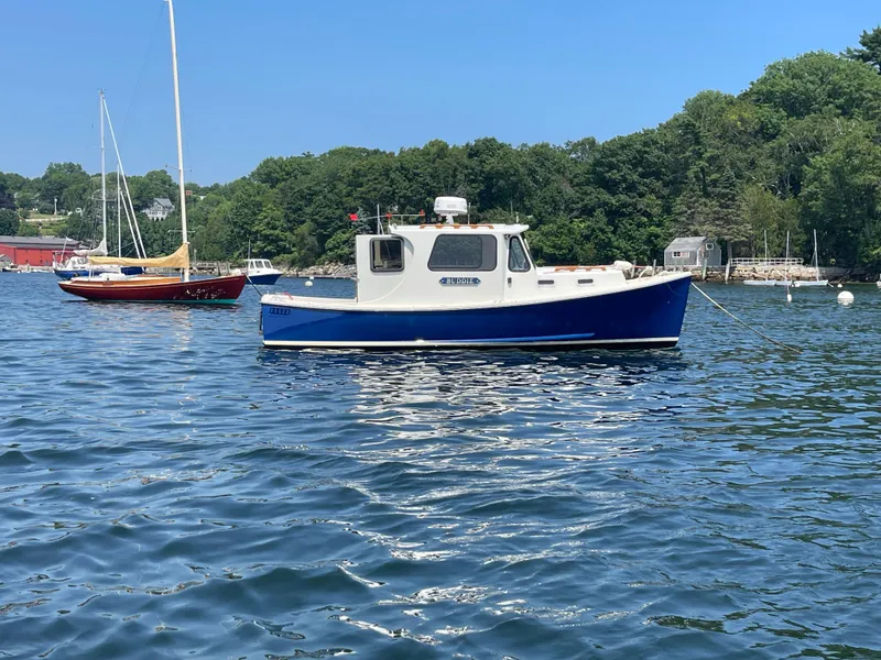 Slide: The Image of 2005 Atlas Boat Works Pompano 21 on calm water, surrounded by lush greenery. - 12