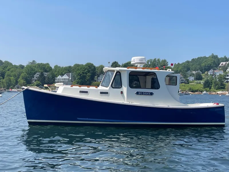 Slide: The Image of 2005 Atlas Boat Works Pompano 21 on water, blue hull, scenic background. - 16