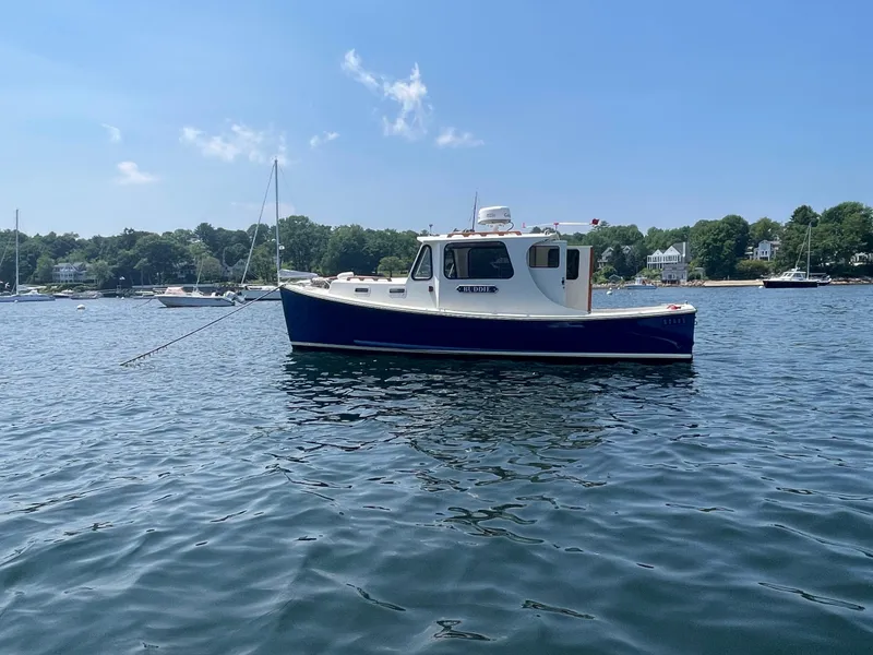 Slide: The Image of 2005 Atlas Boat Works Pompano 21 on calm water, scenic background. - 17