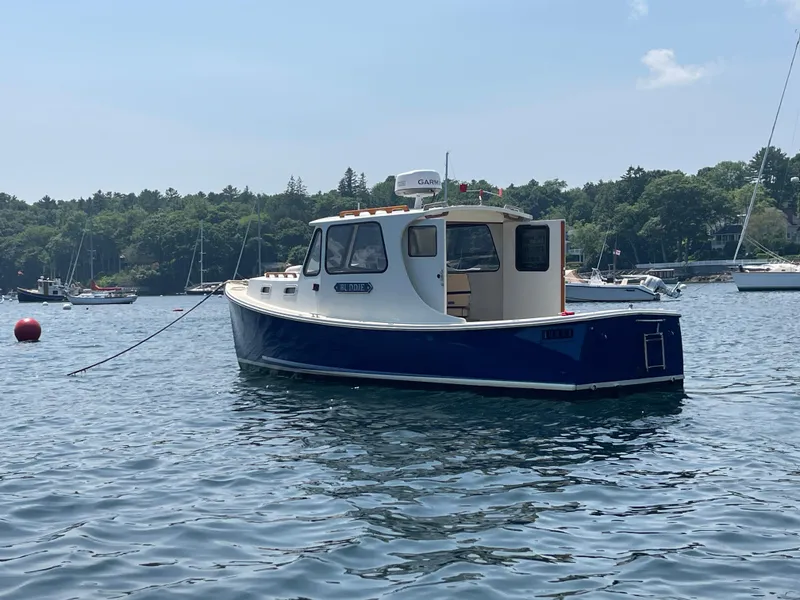 Slide: The Image of 2005 Atlas Boat Works Pompano 21 on calm water, surrounded by other boats. - 19