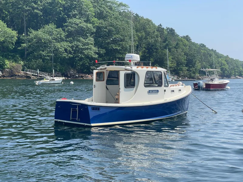 Slide: The Image of 2005 Atlas Boat Works Pompano 21 in scenic harbor with lush green trees. - 2