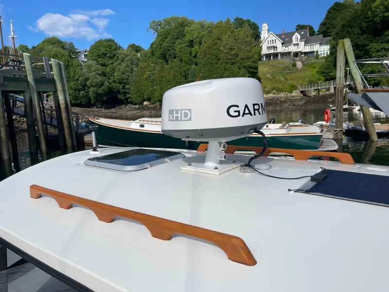 Slide: The Image of 2003 Atlas Boat Works Pompano 21 with Garmin radar, docked near a scenic waterfront. - 21