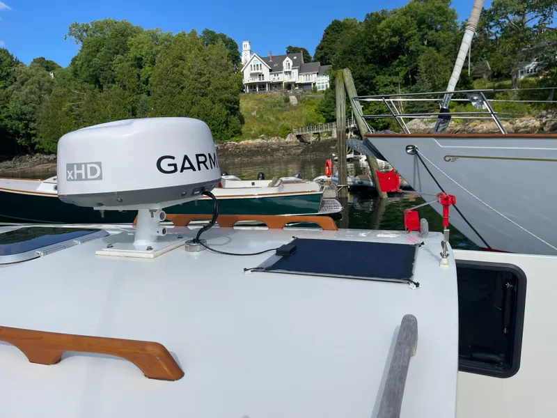 Slide: The Image of 2003 Atlas Boat Works Pompano 21 with Garmin radar, docked near a scenic waterfront. - 22