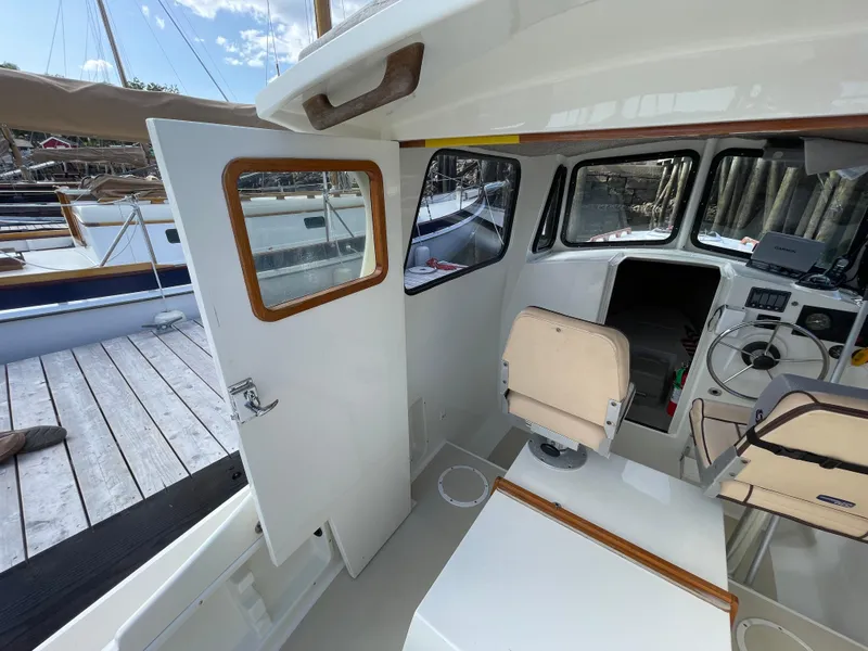 Slide: The Image of Interior of a 2003 Atlas Boat Works Pompano 21, featuring helm and seating area. - 23