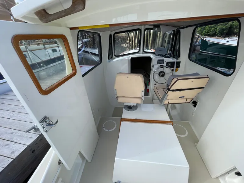 Slide: The Image of Interior of 2003 Atlas Boat Works Pompano 21, featuring helm and seating area. - 24