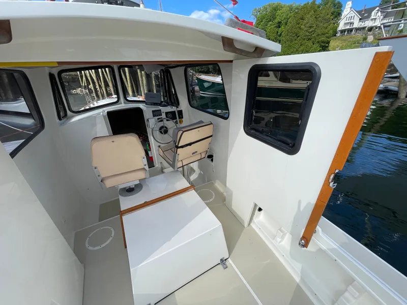 Slide: The Image of Interior of 2003 Atlas Boat Works Pompano 21, featuring helm and seating area. - 25