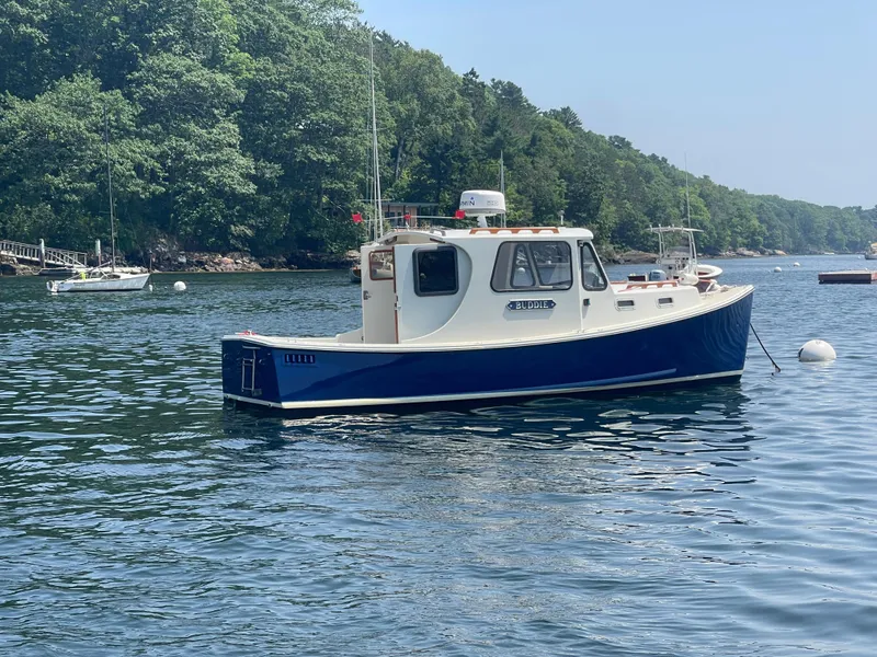 Slide: The Image of 2005 Atlas Boat Works Pompano 21 on calm water, surrounded by lush greenery. - 3
