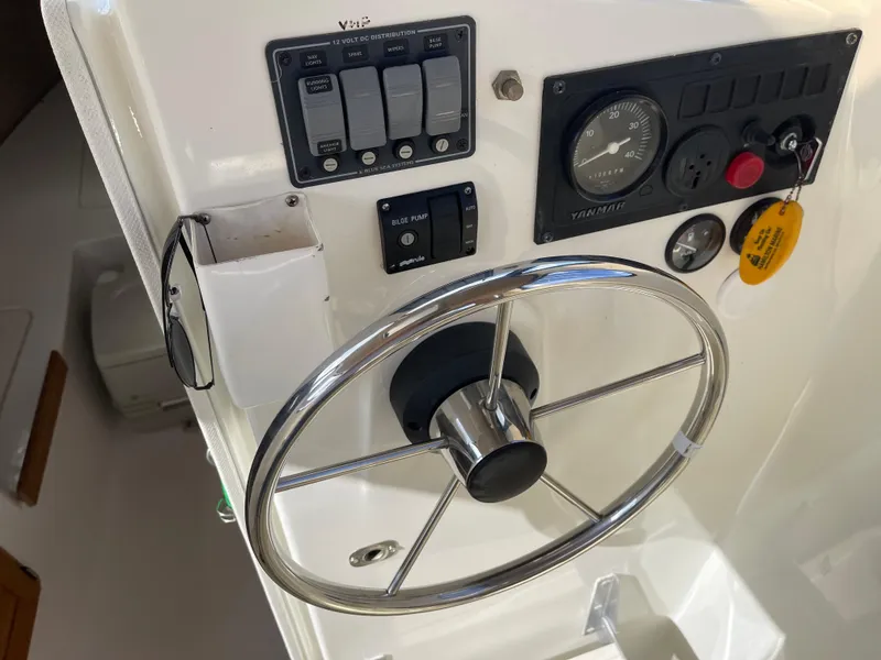 Slide: The Image of Steering console of a 2003 Atlas Boat Works Pompano 21 with gauges and controls. - 33