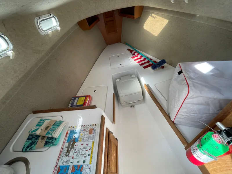 Slide: The Image of Interior of 2003 Atlas Boat Works Pompano 21, featuring compact cabin amenities and storage. - 39