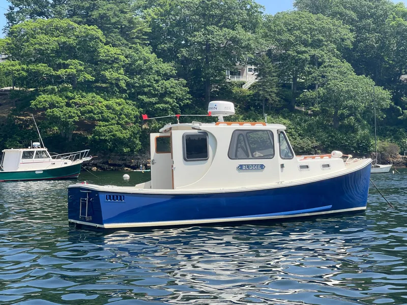Slide: The Image of 2005 Atlas Boat Works Pompano 21 on calm water, surrounded by lush greenery. - 4
