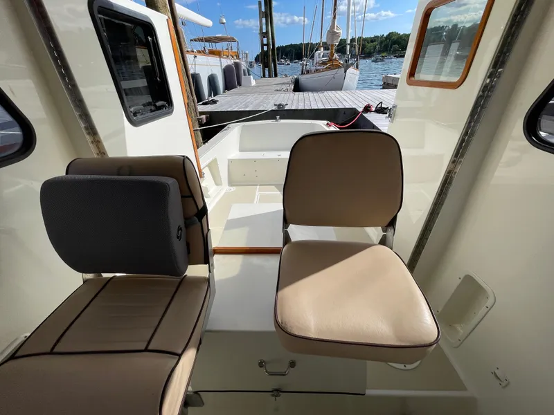 Slide: The Image of Interior view of 2003 Atlas Boat Works Pompano 21, featuring seating and dockside view. - 44