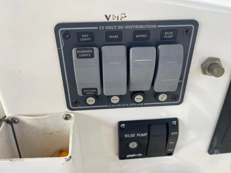 Slide: The Image of Control panel of a 2003 Atlas Boat Works Pompano 21 with switches for lights and bilge pump. - 49