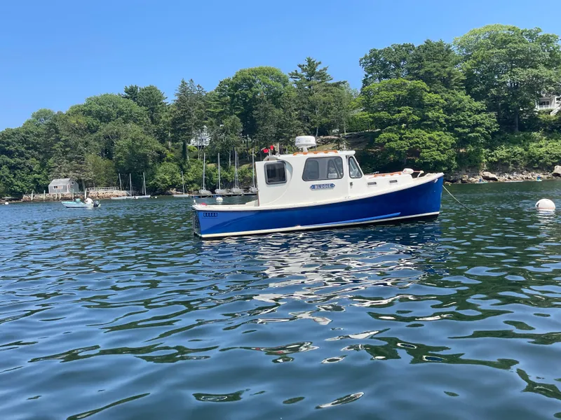 Slide: The Image of 2005 Atlas Boat Works Pompano 21 on calm water, surrounded by lush greenery. - 5