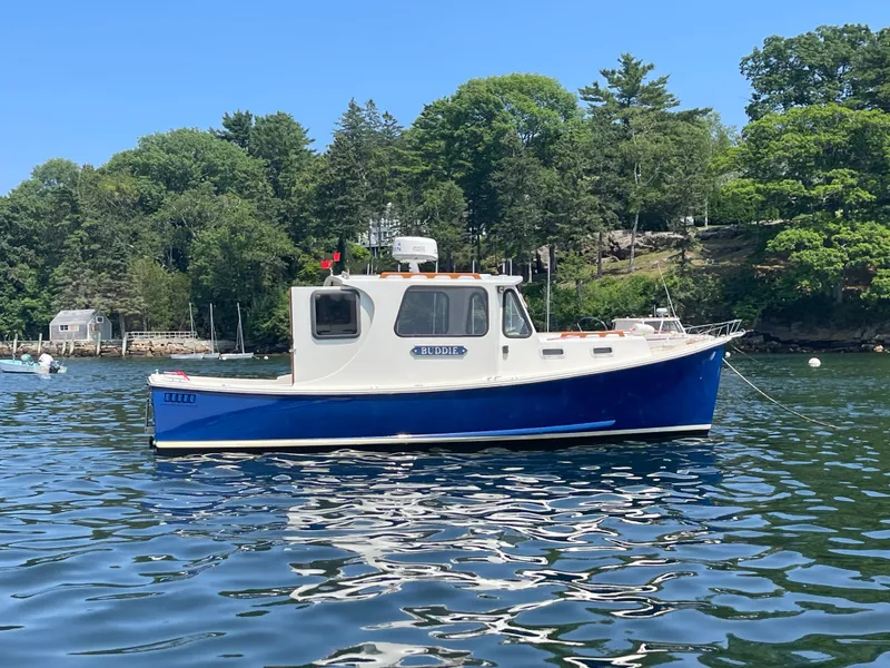 Slide: The Image of 2005 Atlas Boat Works Pompano 21 on calm water, surrounded by lush greenery. - 7