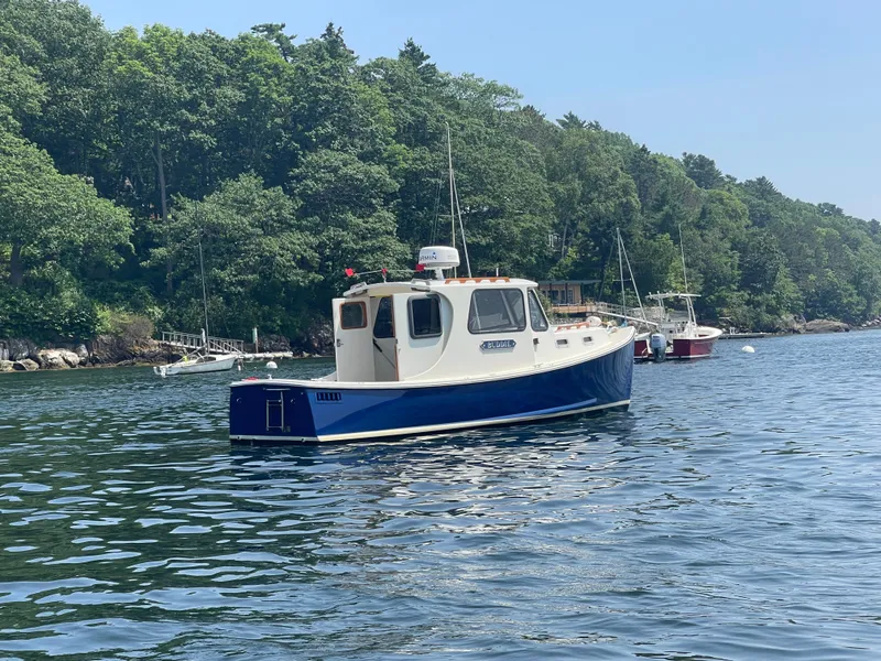 Slide: The Image of 2005 Atlas Boat Works Pompano 21 on scenic water with lush green shoreline. - 8