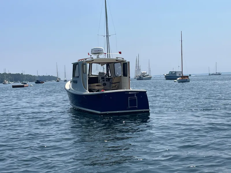 Slide: The Image of 2005 Atlas Boat Works Pompano 21 on calm water, surrounded by sailboats. - 9