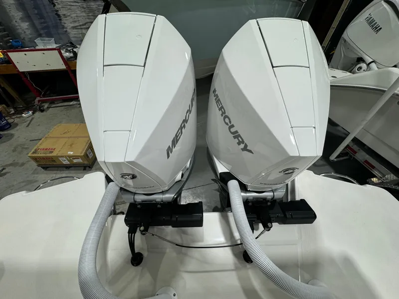 Slide: The Image of Twin Mercury outboard engines on a 2025 Solace 30 HCS boat, in a workshop setting. - 12