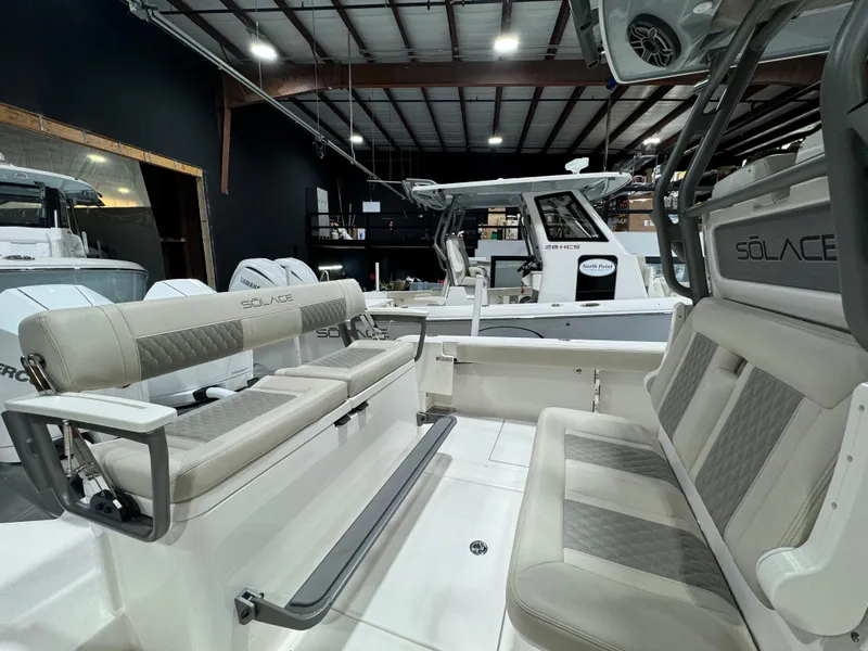 Slide: The Image of 2025 Solace 30 HCS boat interior with cushioned seating in a showroom. - 13