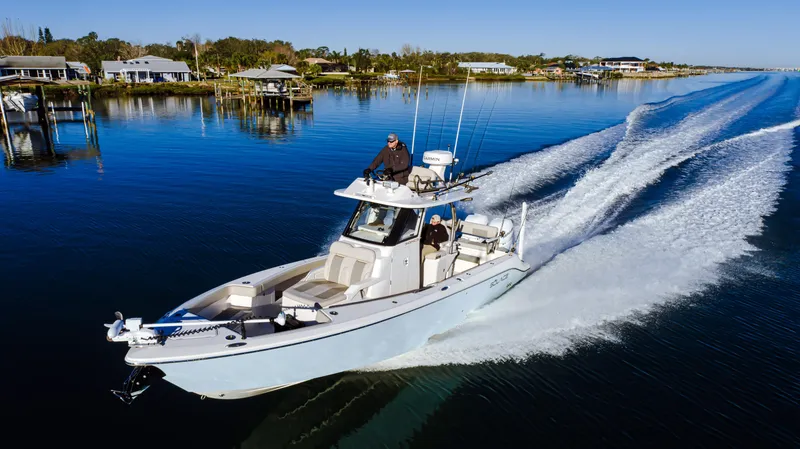 Slide: The Image of 2025 Solace 30 HCS boat cruising on a calm lake under clear blue skies. - 2