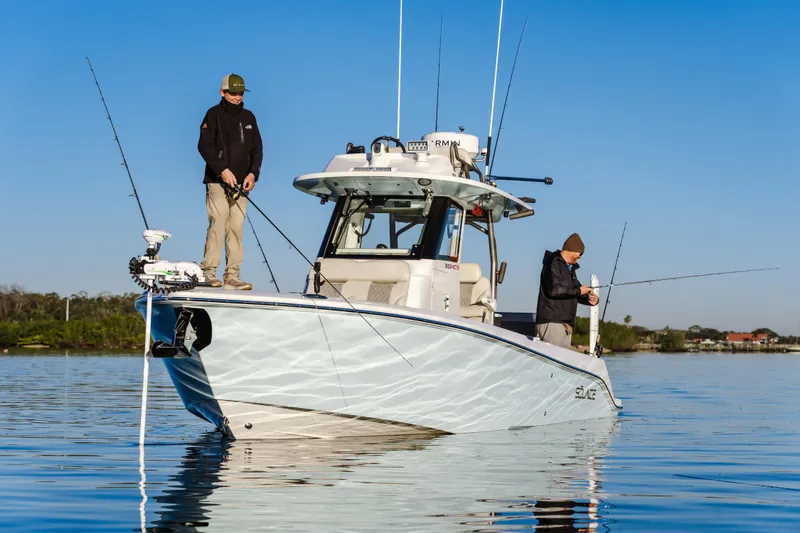 Slide: The Image of 2025 Solace 30 HCS boat with two people fishing on calm water. - 3
