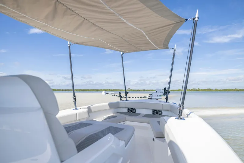 Slide: The Image of 2025 Solace 30 HCS boat interior with canopy, overlooking serene water and blue sky. - 8