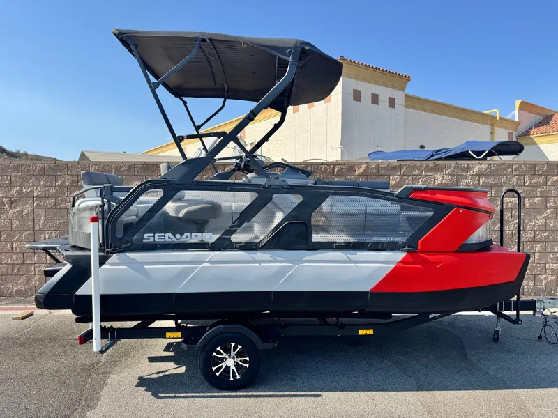 The Image of 2023 Sea-Doo Switch Cruise 18 pontoon boat with canopy, parked on trailer. - 0