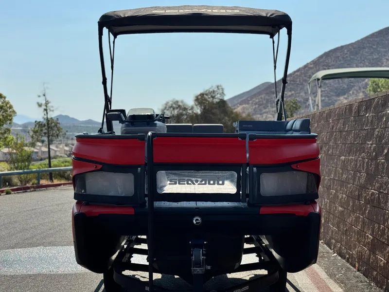 Slide: The Image of 2023 Sea-Doo Switch Cruise 18, red, parked with scenic mountain backdrop. - 2