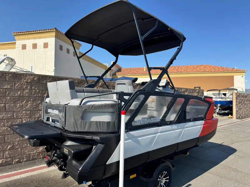 Slide: The Image of 2023 Sea-Doo Switch Cruise 18 pontoon boat with canopy, parked outdoors. - 6