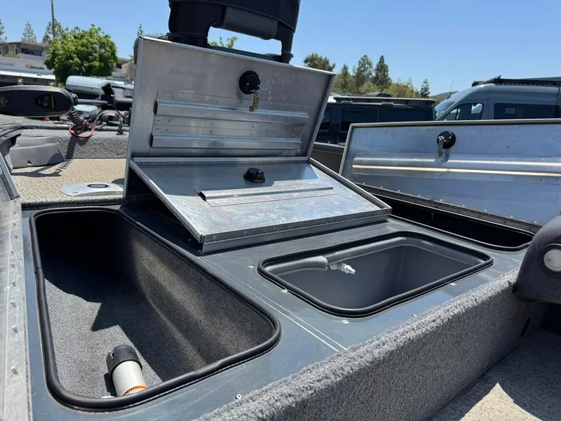 Slide: The Image of 2022 Tracker Pro Team 175 TF boat storage compartments open under sunny sky. - 13
