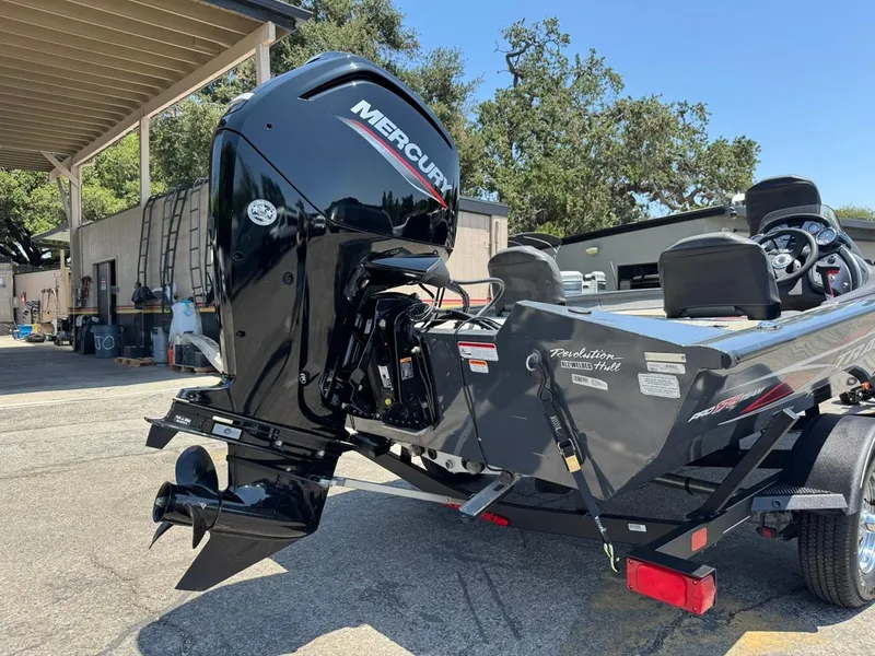 Slide: The Image of 2022 Tracker Pro Team 175 TF boat with Mercury outboard motor, parked outdoors. - 30