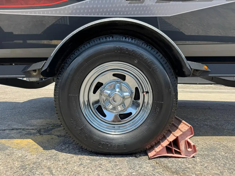 Slide: The Image of 2022 Tracker Pro Team 175 TF trailer wheel on chock, close-up view. - 31