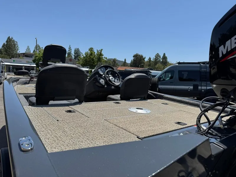 Slide: The Image of 2022 Tracker Pro Team 175 TF boat interior with seating and control panel, parked outdoors. - 4