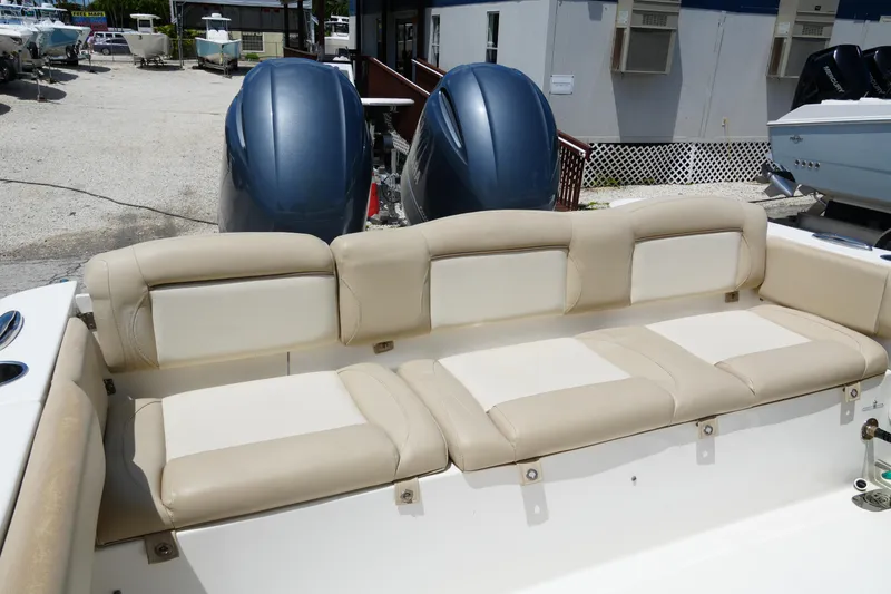 Slide: The Image of 2022 NauticStar 2602 boat with beige seating and dual outboard motors. - 10