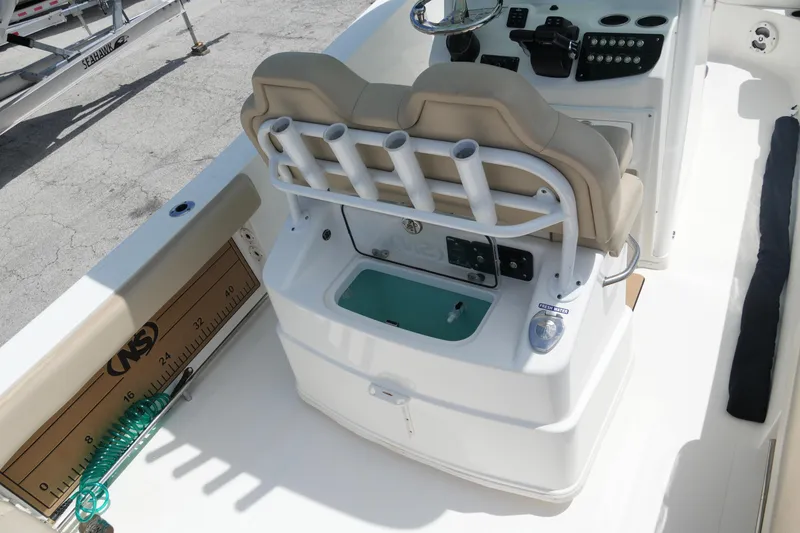 Slide: The Image of 2022 NauticStar 2602 boat interior with helm, rod holders, and measuring board. - 12