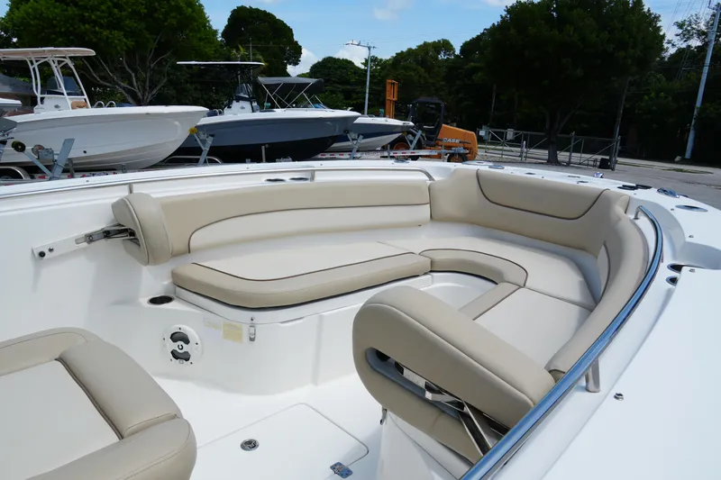 Slide: The Image of 2022 NauticStar 2602 boat with beige seating, docked outdoors. - 16