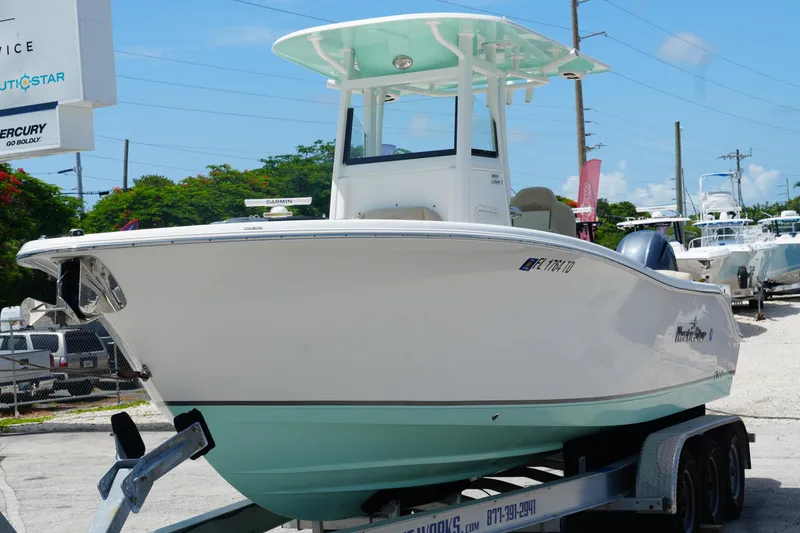 Slide: The Image of 2022 NauticStar 2602 boat on trailer, displayed outdoors at a dealership. - 5
