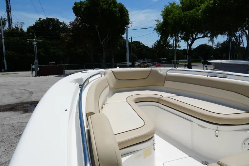 Slide: The Image of 2022 NauticStar 2602 boat with beige seating, docked outdoors under clear skies. - 9